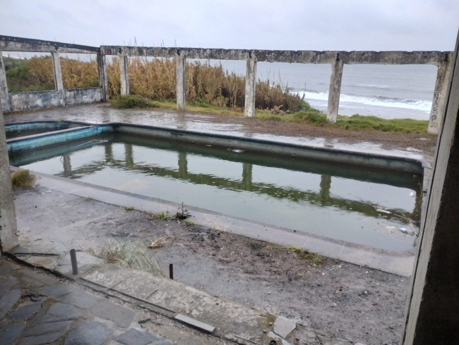 Piscina abandonada frente al mar dentro del predio de Casa Central.