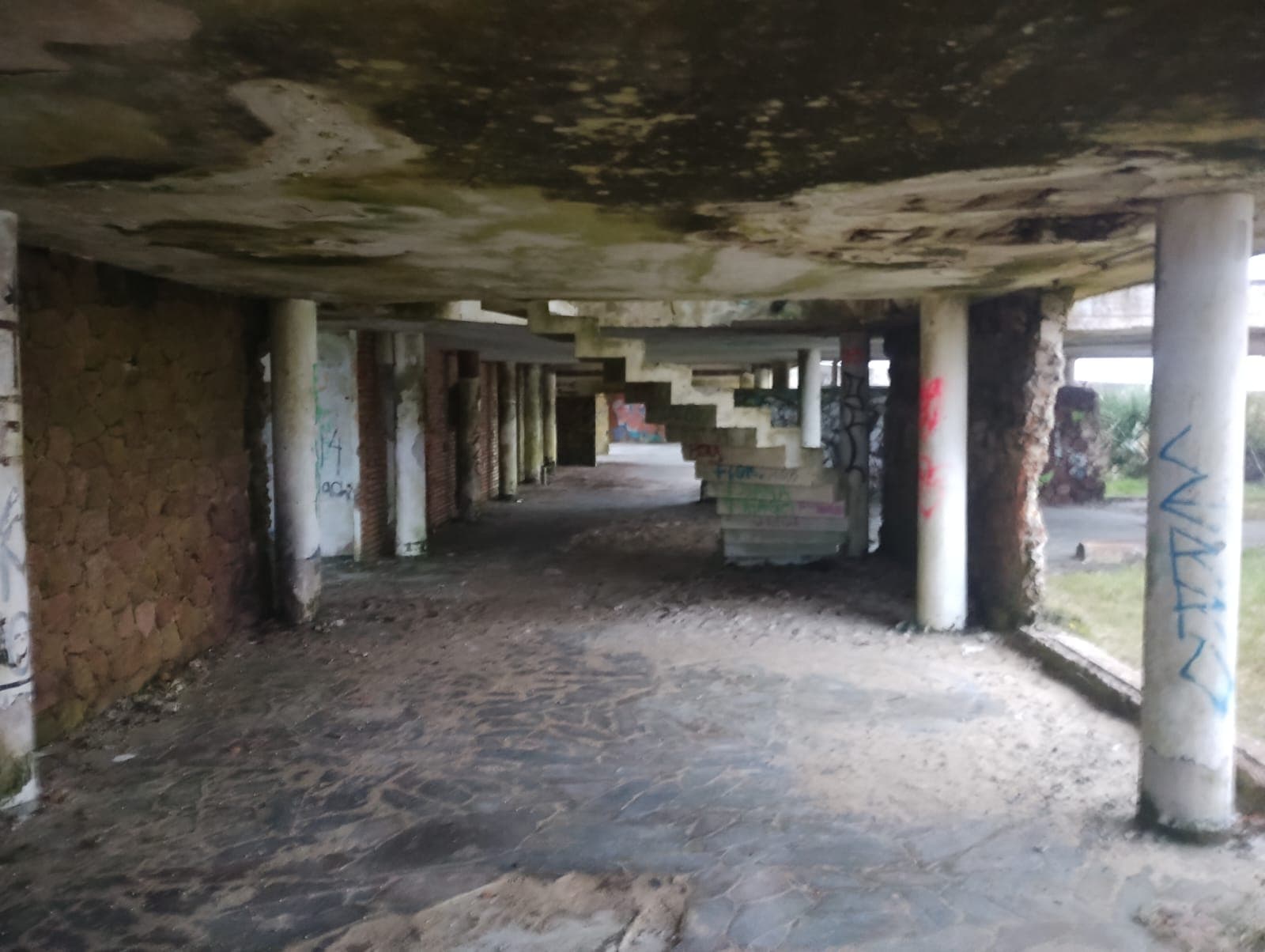 Planta baja abierta con columnas y estructura expuesta.